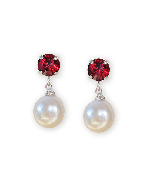 Pair of earrings with red gemstones and pearl drops on a white background
With ruby red crystal round studs about 8mm in size.
