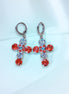 Cross-shaped earrings with red and clight blue gemstones on a light blue 
background
These are made with real Austrian crystals .Rhodium silver plated nickel free 